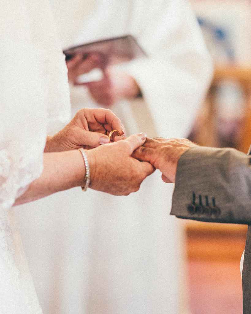 Close-up of a ring being placed on the groom's hand during a Welsh wedding ceremony.