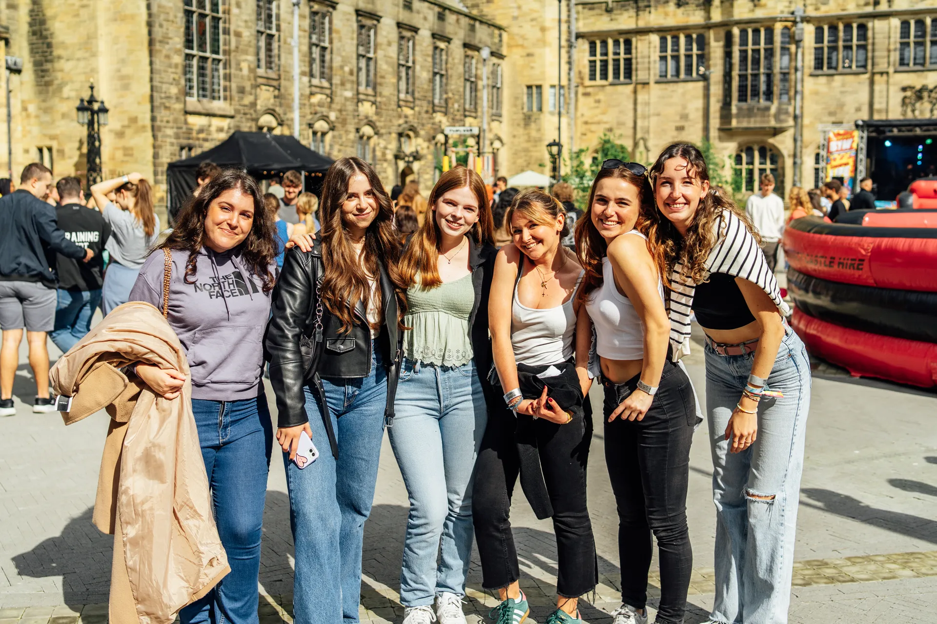 Group of students posing in the Pontio courtyard, sunny day — Academi Summer Ball 2024, Bangor.