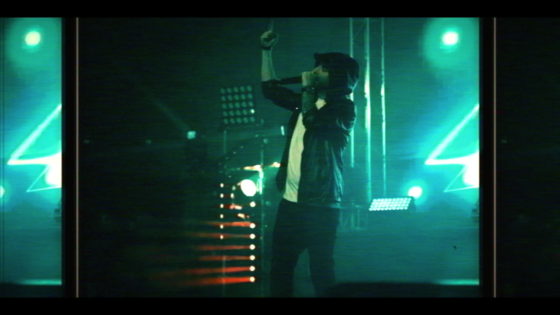 Artist with arm raised under green stage lasers and tribute graphics — Eminem live-show promo, VHS-grain pass-through aesthetic.