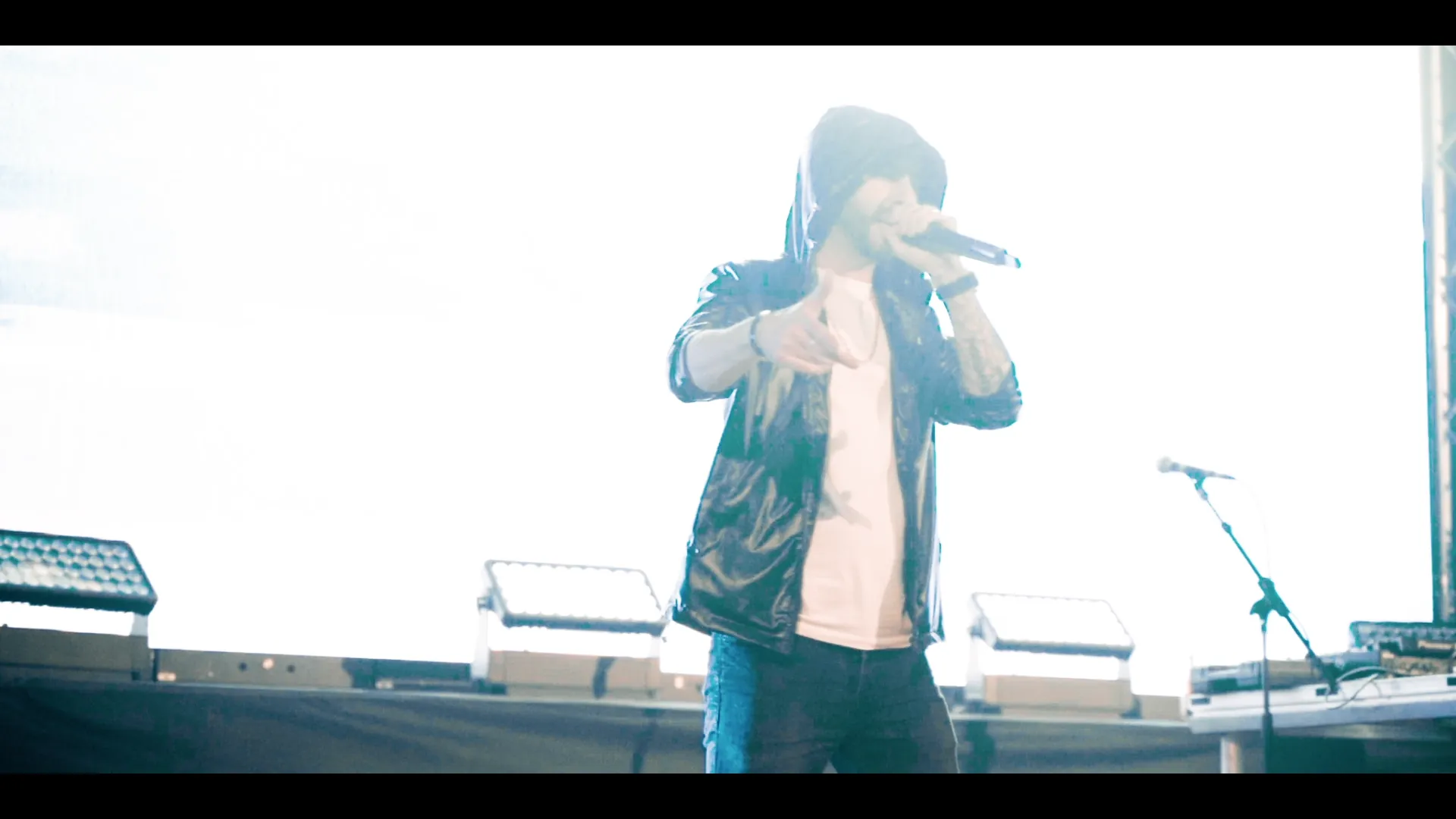 Closing finale frame from the Eminem tribute live-show promo — full-stage colour wash, audience silhouettes, lasers across.