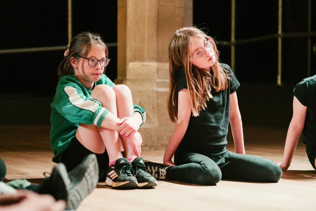 Cwmni Ifanc workshop moment — teenagers in physical theatre warm-up.