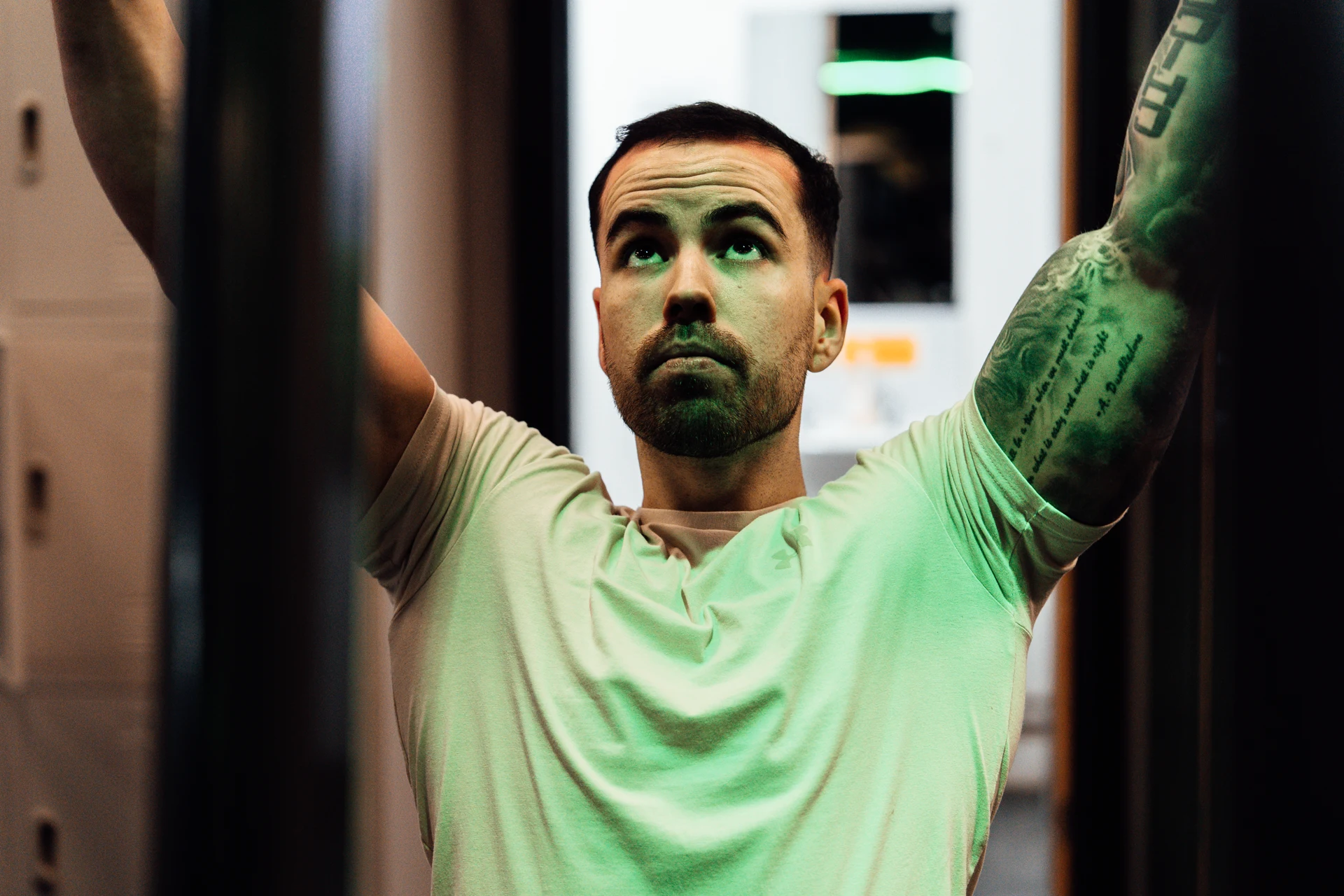 Luis — portrait in characteristic green gym light, Enzone Bangor. Personal trainer brand portrait by Mona Digital.