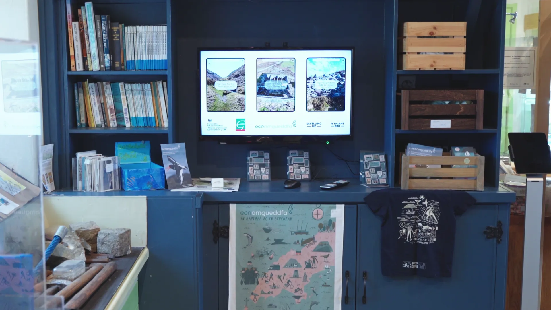 Eco amgueddfa gift shop display at Amgueddfa Forwrol Llŷn — books, magnets, t-shirt and Llŷn wildlife map celebrating the peninsula.