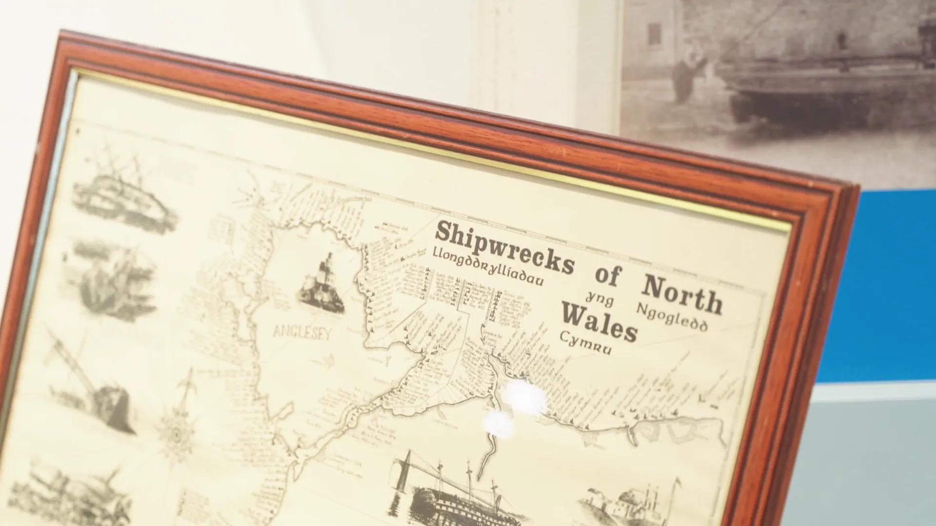 Framed antique map titled Shipwrecks of North Wales / Llongddrylliadau yng Ngogledd Cymru on display at Amgueddfa Forwrol Llŷn.