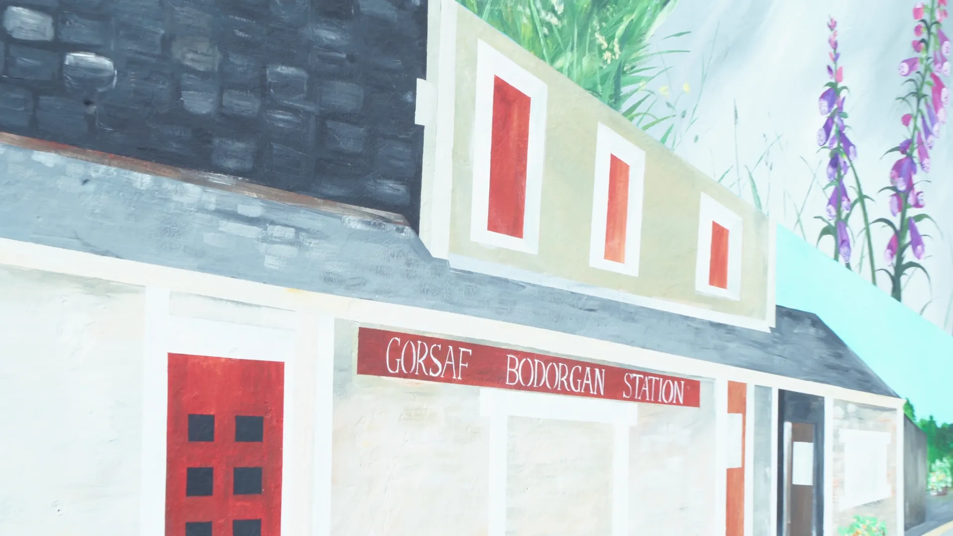 Painted Gorsaf Bodorgan Station mural — village heritage detail filmed for Menter Môn.