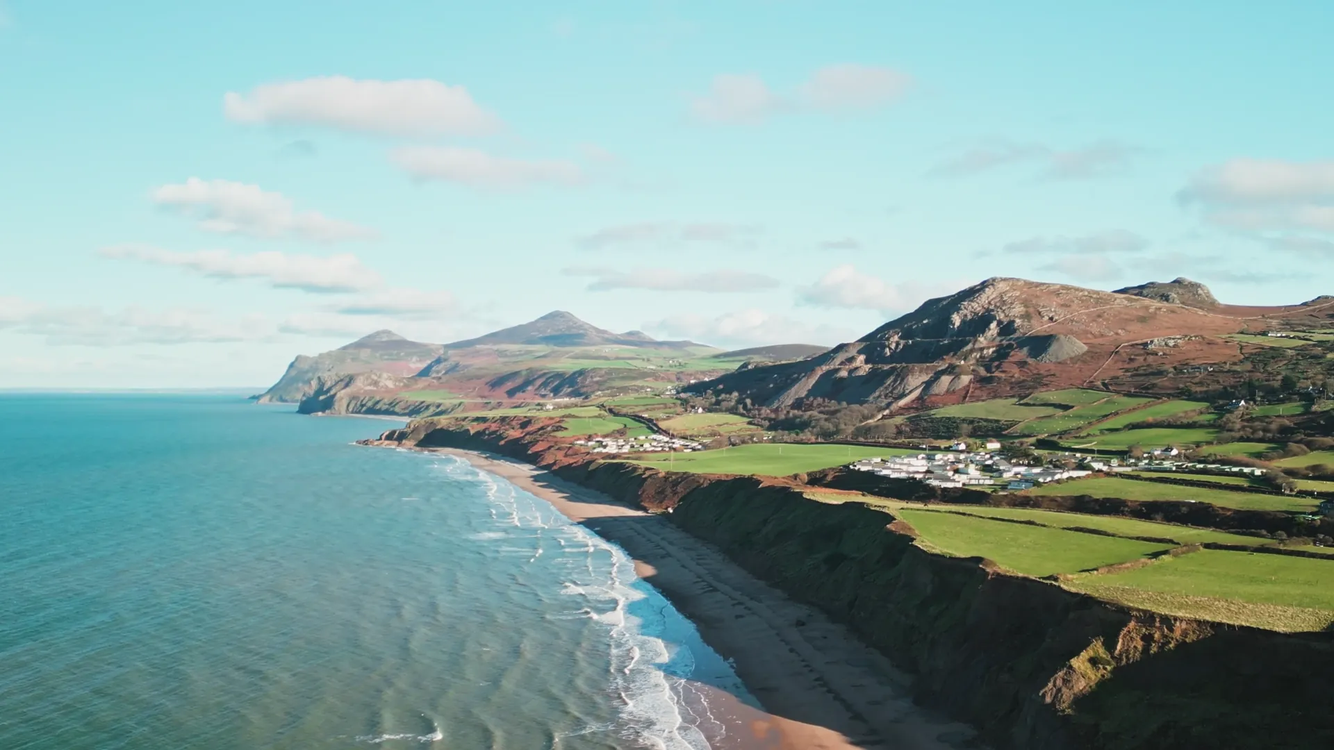 Wide drone aerial of Yr Eifl mountains and Llŷn bay — landscape that frames the Carwyn AP plumbing-and-heating service area, north-west Wales.