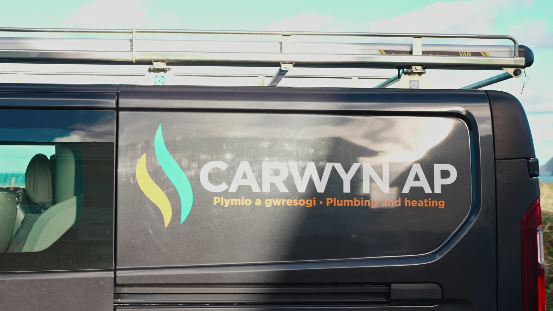 CARWYN AP — Plymio a gwresogi / Plumbing and heating van side-decal in close-up. Welsh-language tradesman branding, Llŷn Peninsula.